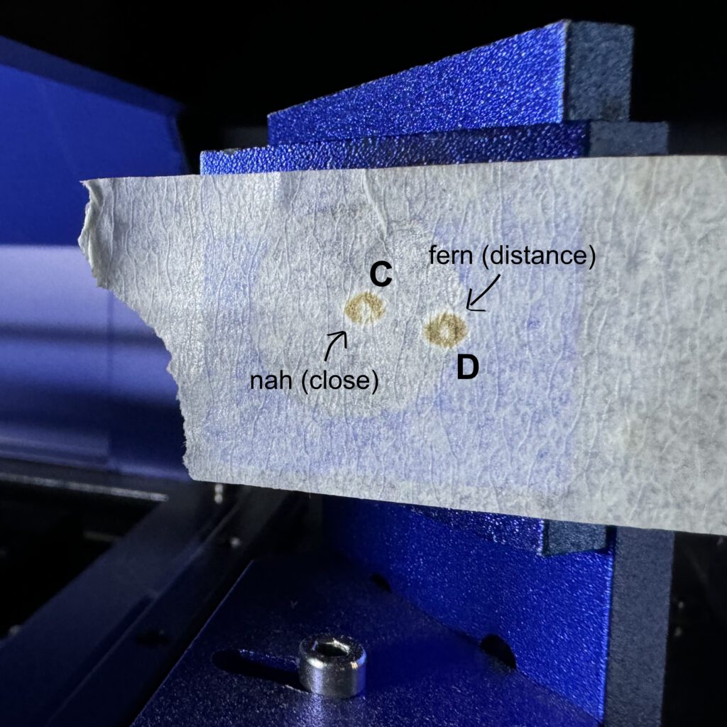 Painter's tape on Mirror 2 with two laser impact points labeled C (close) and D (distant).